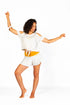 Camiseta Tshirt Comfort con nudo en color blanco Coconut Milk de Yogimi. Camiseta holgada con diseño cómodo y frase bordada "Cuando nada esperas todo llega".
