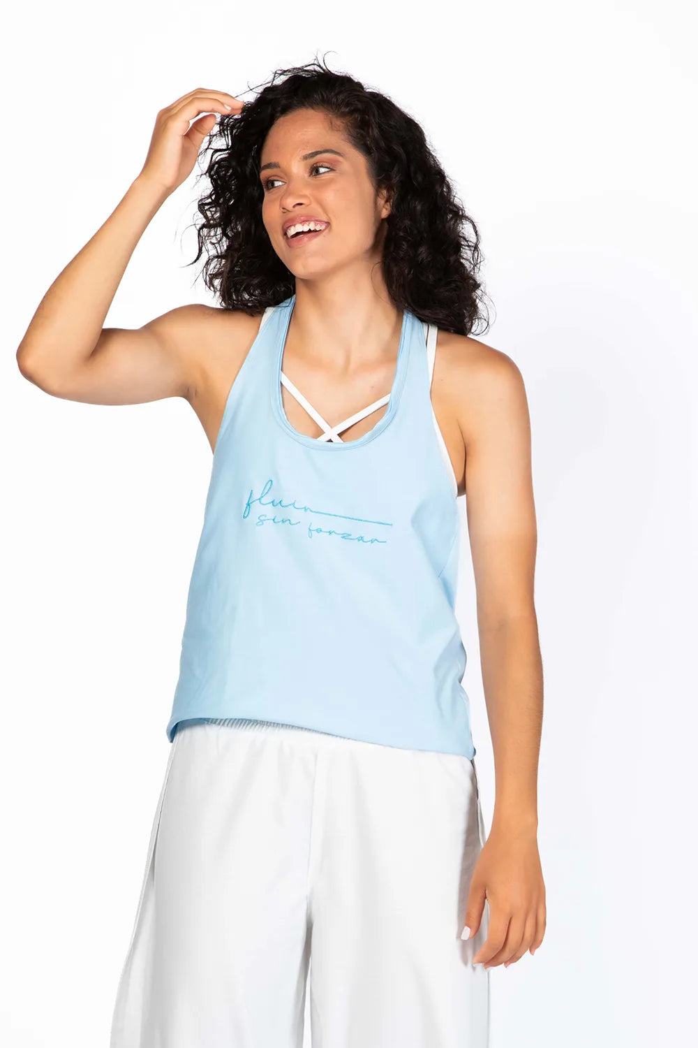 Camiseta Fluir Tank, modelo estilo nadadora en color celeste Ice Water de Yogimi. Camiseta tirantes holgada con mantra "Fluir sin forzar".
