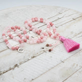 Japa mala de meditación de cuarzo rosa y ágata rosa con borla de seda rosa y detalle de medalla de flor de loto en plata de ley de Yogimi.
