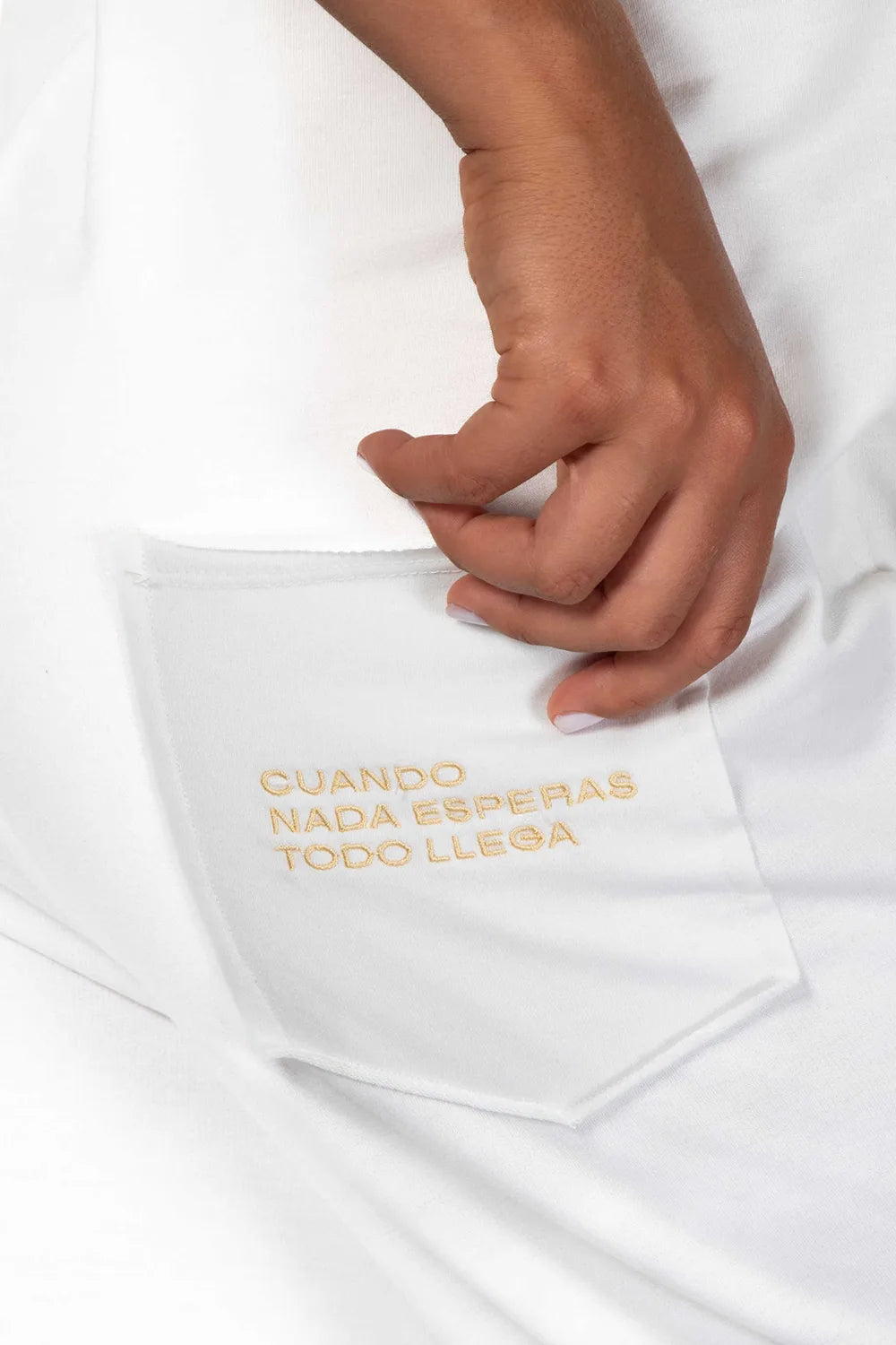 Detalle bordado bolsillo trasero con frase "Cuando nada esperas todo llega". Peto Freedom color blanco Coconut Milk de Yogimi. Esas prendas que una vez te las pones no te quieres quitar.