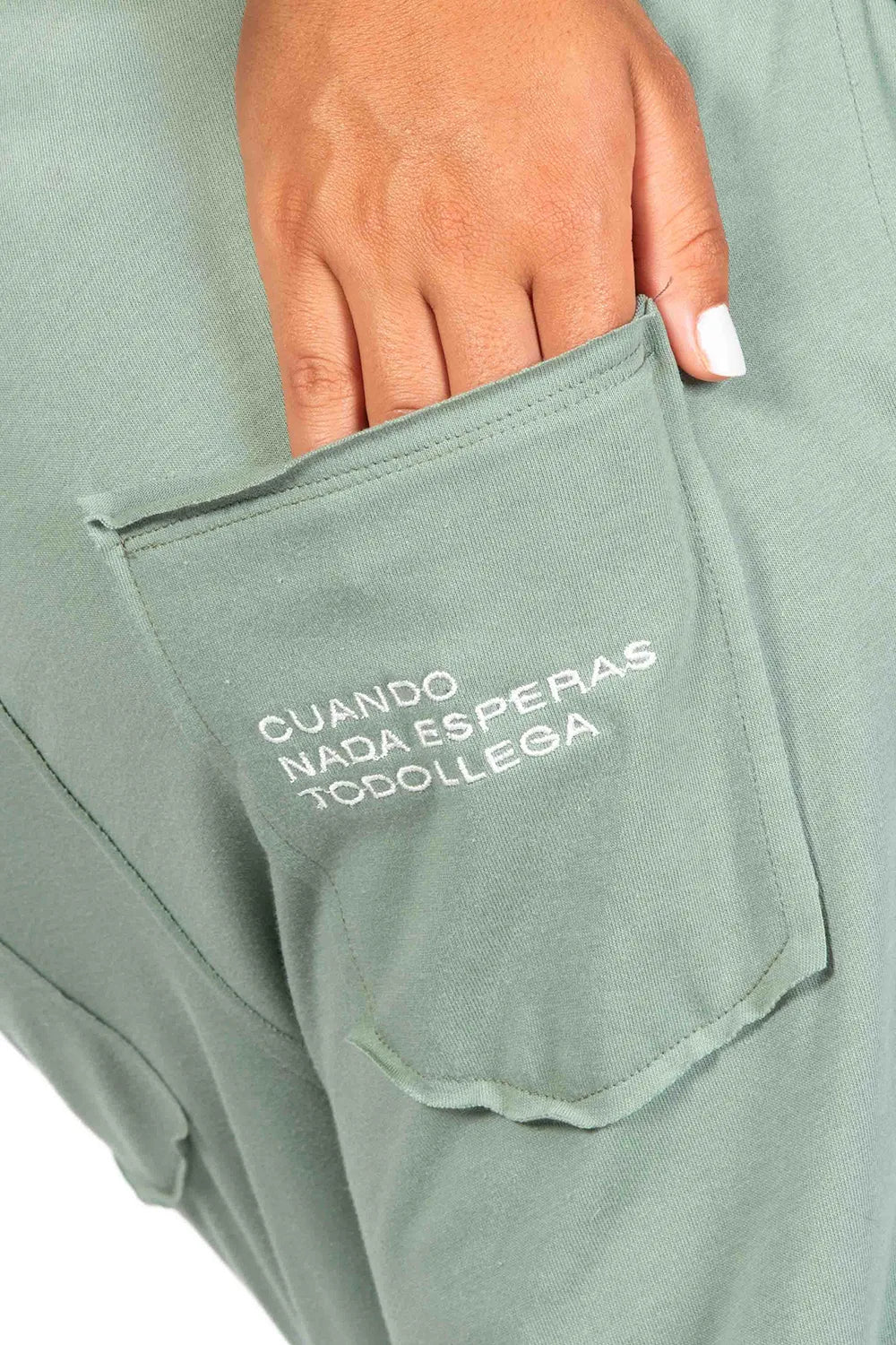 Detalle bordado bolsillo trasero con frase "Cuando nada esperas todo llega". Peto Freedom color verde Green Oil de Yogimi. Esas prendas que una vez te las pones no te quieres quitar.