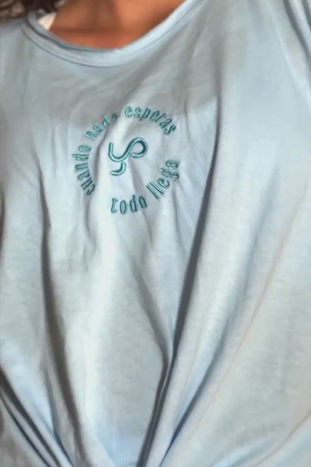 Camiseta Tshirt Comfort con nudo en color celeste Ice Water Yogimi. Camiseta holgada con diseño cómodo y frase bordada &quot;Cuando nada esperas todo llega&quot;.