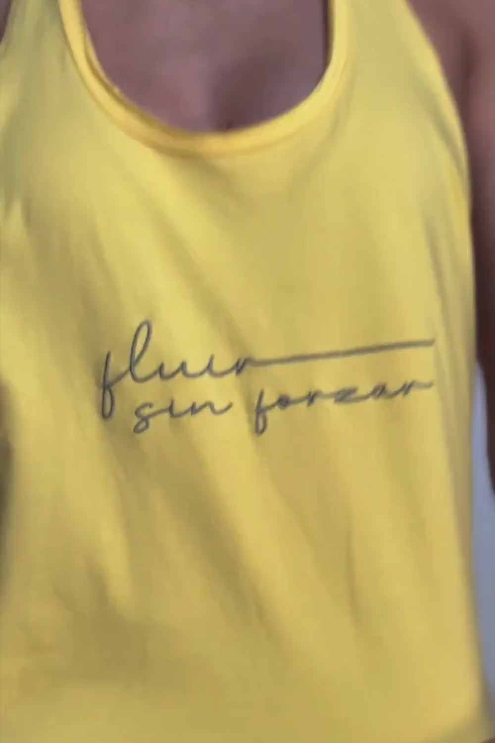 Camiseta Fluir Tank, modelo estilo nadadora en color amarilla Lemon Zest Yogimi. Camiseta tirantes holgada con mantra "Fluir sin forzar".