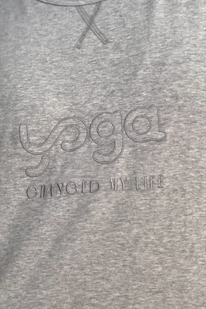 Camiseta Yoga Changed, modelo básico en color gris Quiet Gray de Yogimi. Camiseta manga corta homenaje a amantes del yoga. Bordada con la frase &quot;Yoga Changed My Life&quot;.