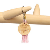 Llavero con borla de seda de color rosa con detalle de madera de Yogimi.